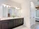 Bright bathroom featuring dual sinks, quartz countertops, and contemporary lighting fixtures at 34163 Radley Way, Wesley Chapel, FL 33545