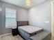 Cozy bedroom with a neutral color palette, window and a comfortable bed setup with bench at 34163 Radley Way, Wesley Chapel, FL 33545