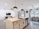 Open-concept kitchen with a large island, stainless steel appliances, and seamless flow to the living area at 34163 Radley Way, Wesley Chapel, FL 33545