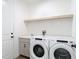 Clean and functional laundry room with modern washer and dryer units and a built in sink at 34163 Radley Way, Wesley Chapel, FL 33545