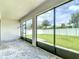 Screened patio overlooking the backyard with green lawn, and a white fence at 34163 Radley Way, Wesley Chapel, FL 33545