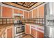 Traditional kitchen with stainless steel appliances, orange wooden cabinets and patterned ceiling at 358 Suwanee Ave, Sarasota, FL 34243