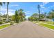 A serene street view showcasing well-maintained lawns, diverse landscaping, and a glimpse of waterfront access at 358 Suwanee Ave, Sarasota, FL 34243