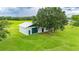 View of the barn on the property surrounded by green grass and a large shade tree at 39905 Townsend Rd, Dade City, FL 33525
