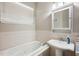 Bright bathroom features a soaking tub with tile surround, pedestal sink and window at 39905 Townsend Rd, Dade City, FL 33525
