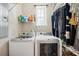 Functional laundry room with modern washer and dryer, shelving, and hanging rack at 39905 Townsend Rd, Dade City, FL 33525