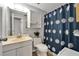 Bathroom with shower, blue flower shower curtain, vanity, and white cabinets at 4215 E Bay Dr # 1801E, Clearwater, FL 33764