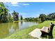 A tranquil view of a pond with a bench to sit, amidst lush greenery, offers a peaceful setting at 4215 E Bay Dr # 1801E, Clearwater, FL 33764
