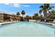 Beautiful community pool with lounge chairs, palm trees, and well-maintained landscaping for relaxation at 4215 E Bay Dr # 1801E, Clearwater, FL 33764
