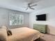 Bright bedroom features a ceiling fan, large window, and stylish dresser at 4338 Banjo Lake Rd, Land O Lakes, FL 34639