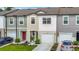 Charming townhome features a colorful door, manicured landscaping, and attached garage at 4338 Banjo Lake Rd, Land O Lakes, FL 34639