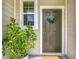 Inviting front door with a wreath, bright sidelight window, and a charming potted plant at 4338 Banjo Lake Rd, Land O Lakes, FL 34639