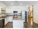 Bright kitchen features stainless appliances, granite countertops, white cabinets, island and wood floor at 4338 Banjo Lake Rd, Land O Lakes, FL 34639