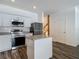 Bright kitchen features stainless appliances, granite countertops, white cabinets, island and wood floor at 4338 Banjo Lake Rd, Land O Lakes, FL 34639