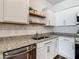Kitchen features stainless steel appliances, white cabinets, floating shelves and granite countertops at 4338 Banjo Lake Rd, Land O Lakes, FL 34639