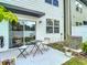 Cozy patio area with table and chairs, sliding door entrance, and green shrubs at 4338 Banjo Lake Rd, Land O Lakes, FL 34639