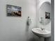 Elegant powder room with pedestal sink, round mirror, and stylish wall decor at 4338 Banjo Lake Rd, Land O Lakes, FL 34639