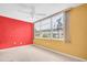 A bright bedroom has a large window offering natural light and colorful walls at 5720 13Th N Ave # 207B, St Petersburg, FL 33710