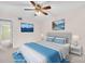 A bedroom with mountain scene wall art, ceiling fan and nicely styled bed at 5720 13Th N Ave # 207B, St Petersburg, FL 33710