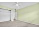 Bedroom featuring neutral carpet, light green walls, ceiling fan, and closet with a door at 5720 13Th N Ave # 207B, St Petersburg, FL 33710