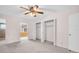 Bedroom with a ceiling fan, open closets, and an open doorway to another room at 5720 13Th N Ave # 207B, St Petersburg, FL 33710