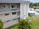 Three-story condo building featuring balconies, a white carport, and nicely maintained landscaping at 5720 13Th N Ave # 207B, St Petersburg, FL 33710