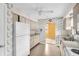 Kitchen featuring white cabinets and appliances, decorative wallpaper and vinyl floor at 5720 13Th N Ave # 207B, St Petersburg, FL 33710