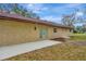 Back of house with stucco walls, sliding glass doors, and a small window at 5749 Southernview Dr, Zephyrhills, FL 33541