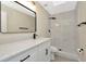 Modern bathroom featuring a marble-tiled shower and a white vanity with black fixtures at 5749 Southernview Dr, Zephyrhills, FL 33541