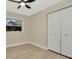 A bedroom with a ceiling fan, vinyl plank flooring, and closet with doors closed and window view at 5749 Southernview Dr, Zephyrhills, FL 33541