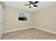 Neutral bedroom with hardwood floors, a ceiling fan, and a bright window at 5749 Southernview Dr, Zephyrhills, FL 33541
