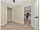 A bedroom with a closet with open doors next to an open doorway with kitchen view at 5749 Southernview Dr, Zephyrhills, FL 33541