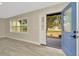 Inviting entryway with a bright blue door and a view to a landscaped front yard at 5749 Southernview Dr, Zephyrhills, FL 33541