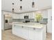 Bright kitchen with white cabinetry, quartz countertops, stainless steel appliances, and a large island at 5749 Southernview Dr, Zephyrhills, FL 33541