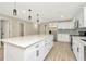Spacious kitchen with a large island, white cabinets, stainless steel appliances, and modern lighting at 5749 Southernview Dr, Zephyrhills, FL 33541