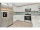Bright kitchen with stainless steel appliances, white cabinets, quartz countertops, and modern flooring at 5749 Southernview Dr, Zephyrhills, FL 33541