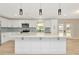 Modern kitchen featuring white cabinets, a large island with quartz countertops, and stainless appliances at 5749 Southernview Dr, Zephyrhills, FL 33541