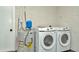 Laundry area with new Samsung washer and dryer units next to hot water tank in textured wall room at 5749 Southernview Dr, Zephyrhills, FL 33541