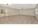 Bright, open living room with neutral walls, wood floors, and modern lighting fixtures at 5749 Southernview Dr, Zephyrhills, FL 33541