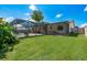 Expansive backyard with a screened pool, covered patio, and ample green space, perfect for outdoor enjoyment at 630 Kirkland Cir, Dunedin, FL 34698