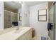 Bathroom featuring a vanity, framed mirror, and walk-in shower with tile surround and decorative starfish at 630 Kirkland Cir, Dunedin, FL 34698
