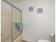 Bathroom featuring a tub/shower combo with glass doors, nautical wall decor, and a toilet at 630 Kirkland Cir, Dunedin, FL 34698