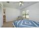 Bright bedroom featuring a ceiling fan, neutral carpet, window with blinds, and a relaxing chair at 630 Kirkland Cir, Dunedin, FL 34698
