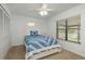 Light-filled bedroom featuring a ceiling fan, window with blinds, and a comfy bed with blue bedding at 630 Kirkland Cir, Dunedin, FL 34698
