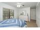 Bright bedroom with a blue patterned bedspread, white dresser, and view of the outdoor pool through the window at 630 Kirkland Cir, Dunedin, FL 34698