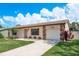 Single-story home with stone accents and attached one-car garage featuring a well-manicured lawn at 630 Kirkland Cir, Dunedin, FL 34698