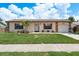 Charming single-story home with stone accents, well-maintained lawn, and a delightful palm tree at 630 Kirkland Cir, Dunedin, FL 34698