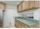 Kitchen featuring wood cabinets, countertops, a door to the outside, and a window to another room at 630 Kirkland Cir, Dunedin, FL 34698