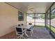 Screened-in patio area with outdoor dining set and view of the fenced-in backyard at 630 Kirkland Cir, Dunedin, FL 34698