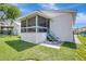 Landscaped backyard with a screened-in porch featuring green trim, perfect for outdoor entertaining and relaxation at 6603 S Juanita St, Tampa, FL 33616